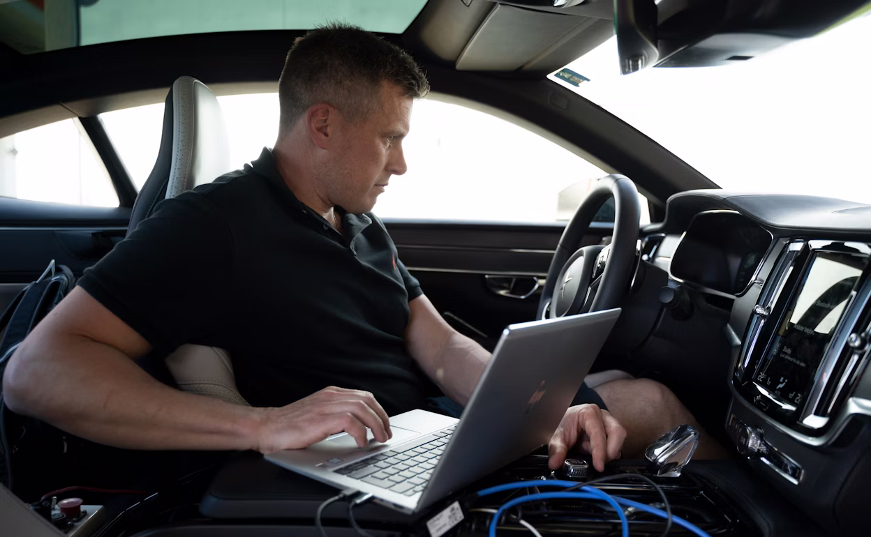 A man with a computer configuring software inside a Polestar 1.