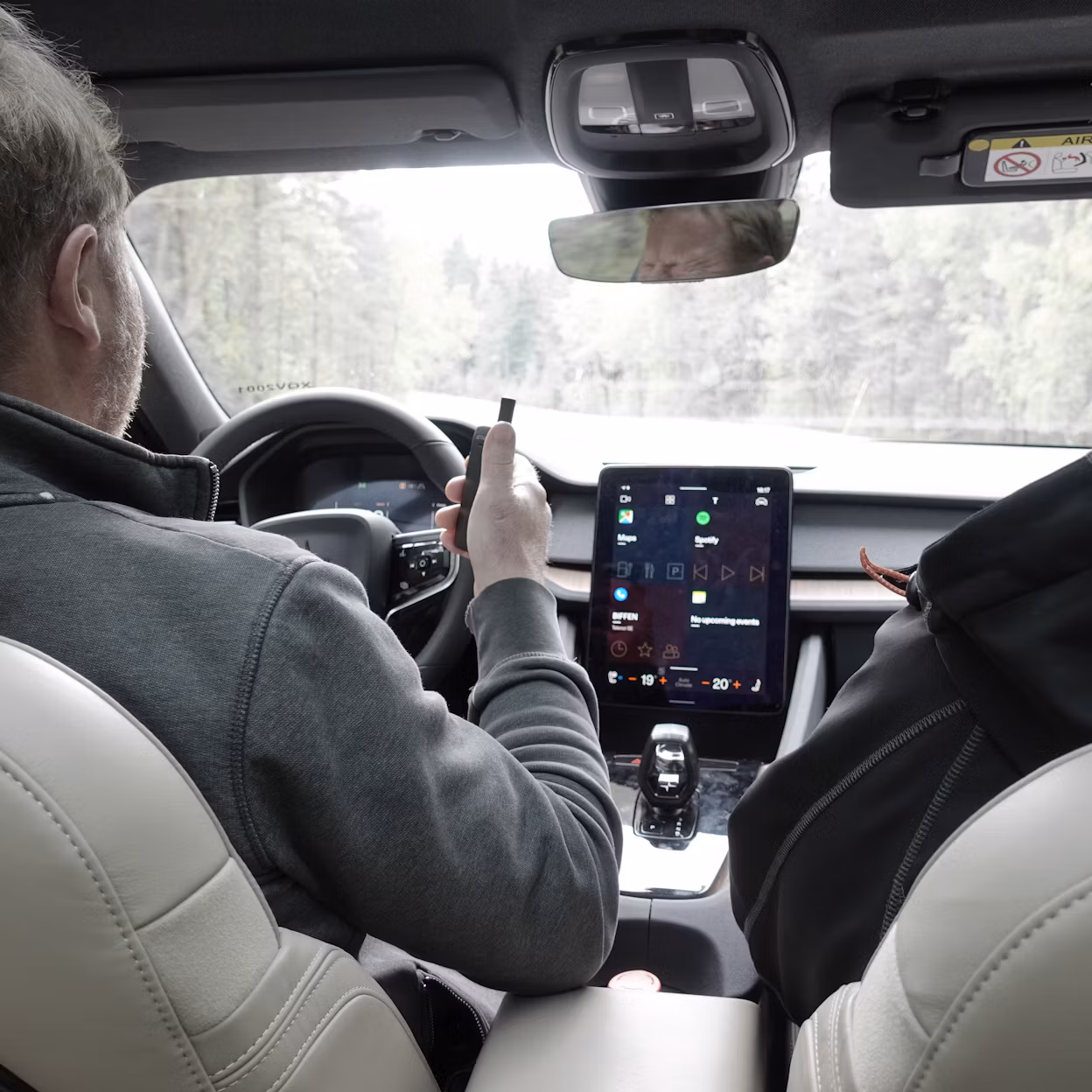 Two people sitting in the front seats of a Polestar 2.