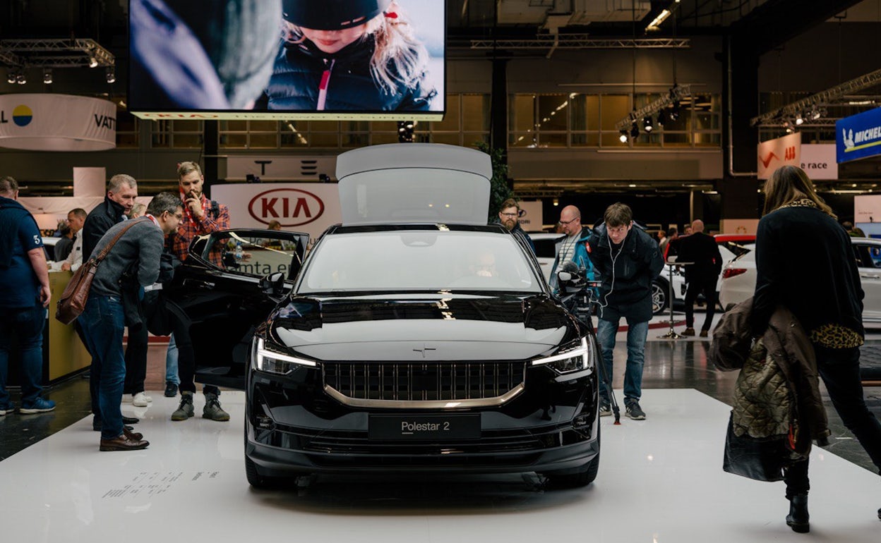 Event visitors inspecting a black Polestar 2 at Ecar expo 2019.