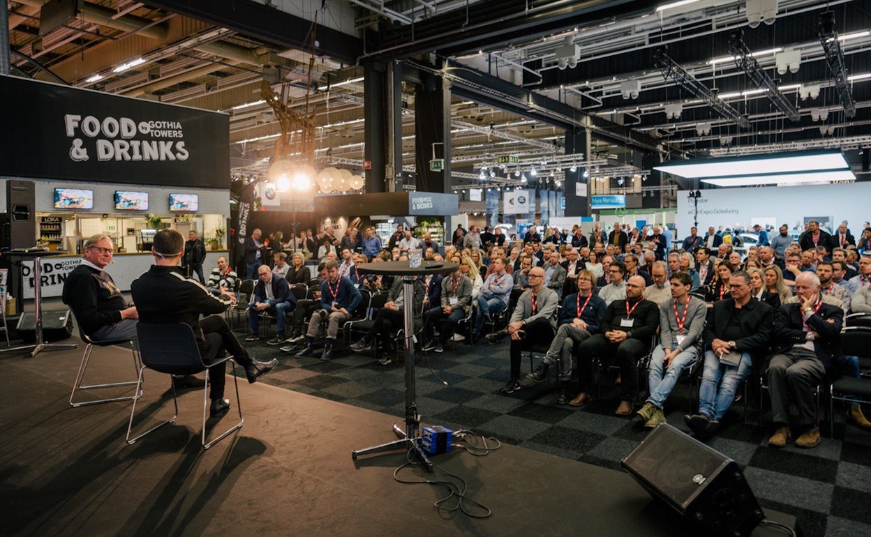 Seated audience listening to a panel talk on stage at Ecar expo 2019.