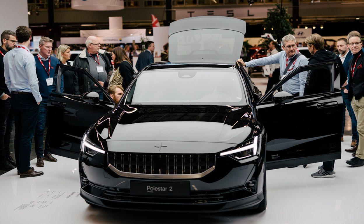 Event visitors inspecting a black Polestar 2 with open doors at Ecar expo 2019.