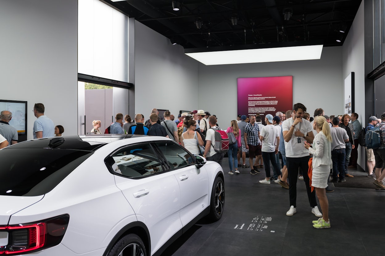 Exhibition visitors gathered around a white Polestar 1 inside show space at the Goodwood Festival.