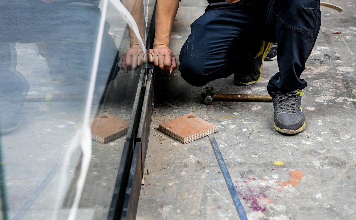 A worker kneeling while building the Polestar stand.