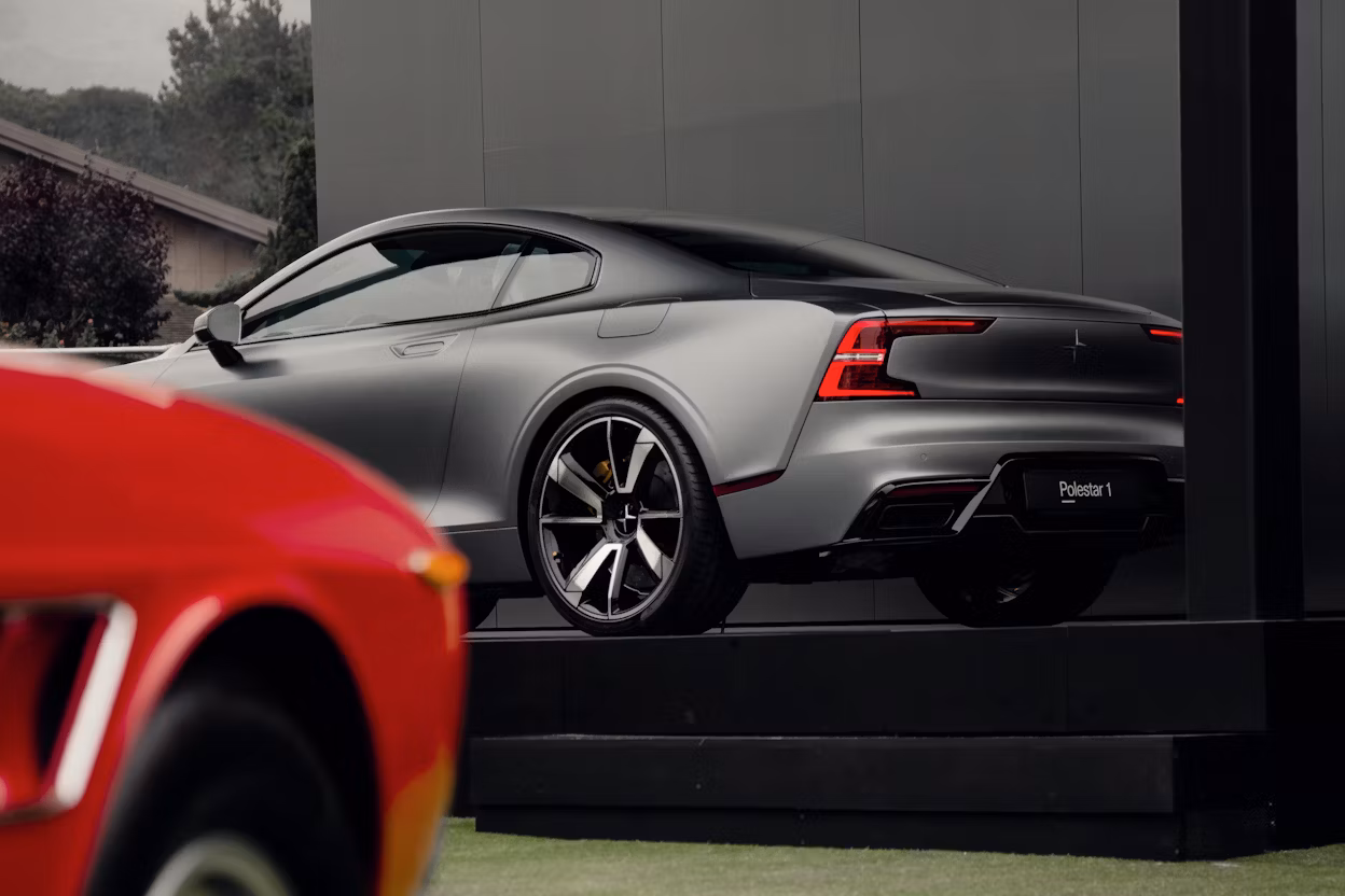 Side view of a silver Polestar 1 in a exhibition space.