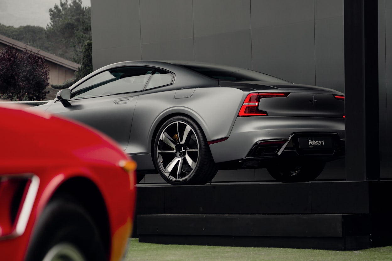 Side view of a silver Polestar 1 in a exhibition space.