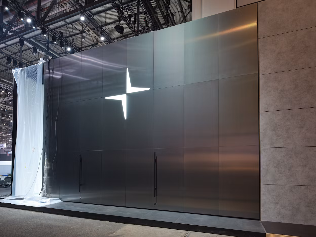 The Polestar logo on a shiny metallic wall.