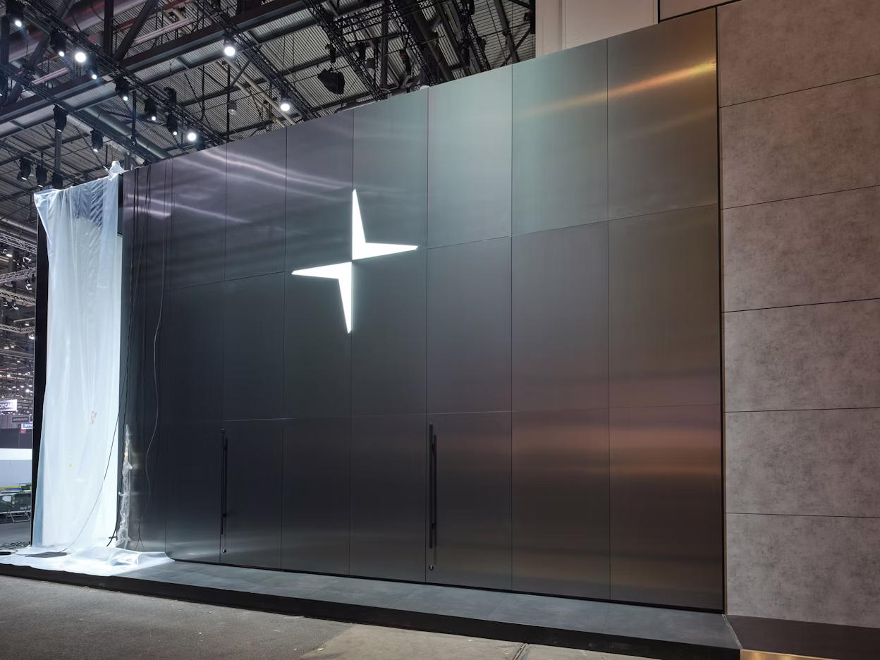 The Polestar logo on a shiny metallic wall.