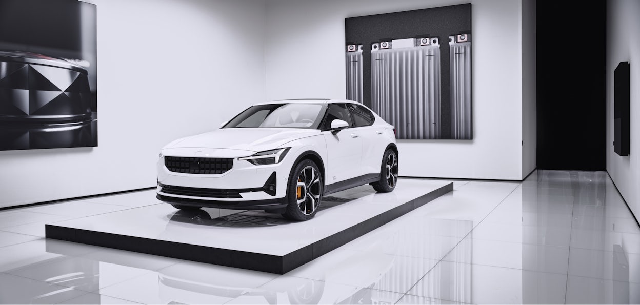 A white Polestar 2 on display in a minimalistic Polestar space.