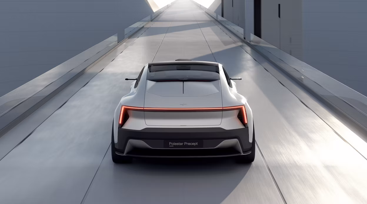 Back view of a grey Polestar Precept driving on a grey road.