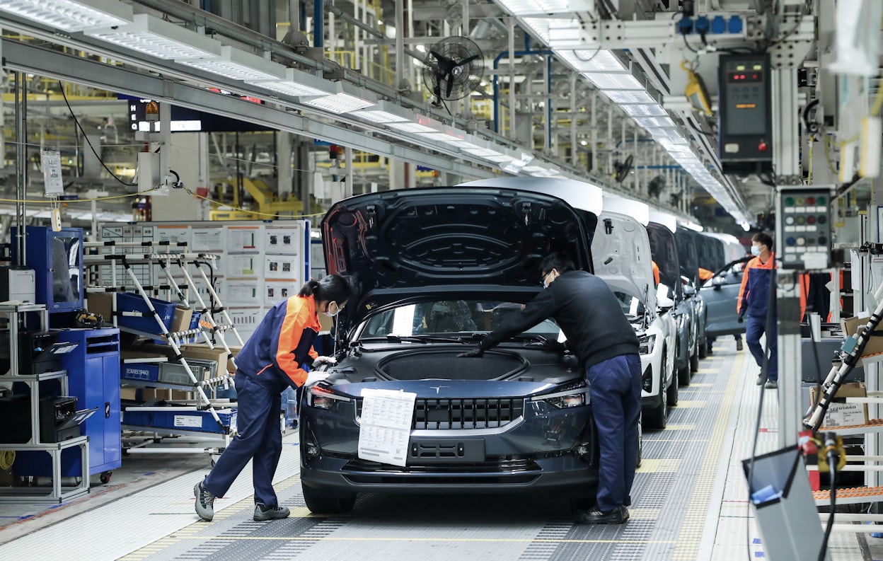 Numerous Polestar 2 in different colours being assembled on the production floor.