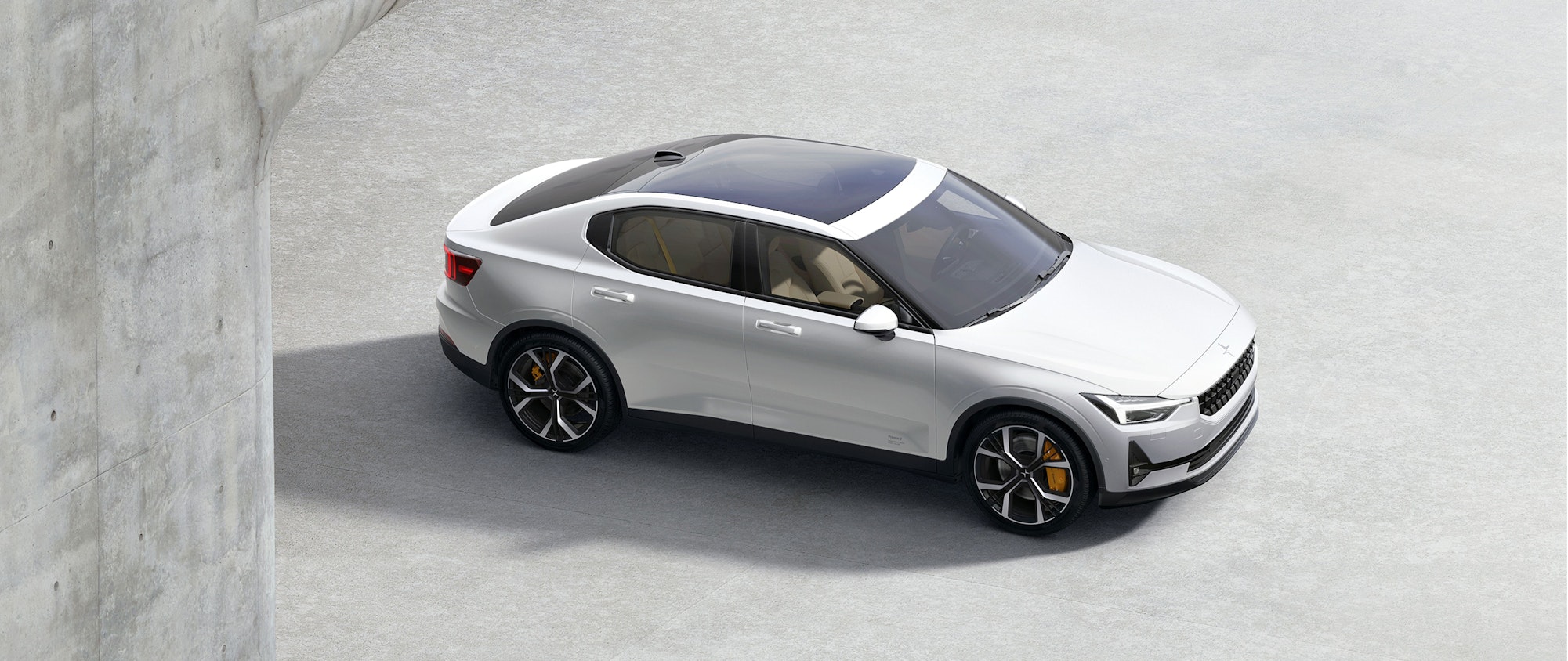 A white Polestar 2 from above, standing in a parking space.