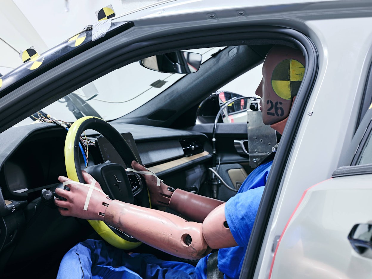 A crash test dummy behind the wheel in a Polestar 2.