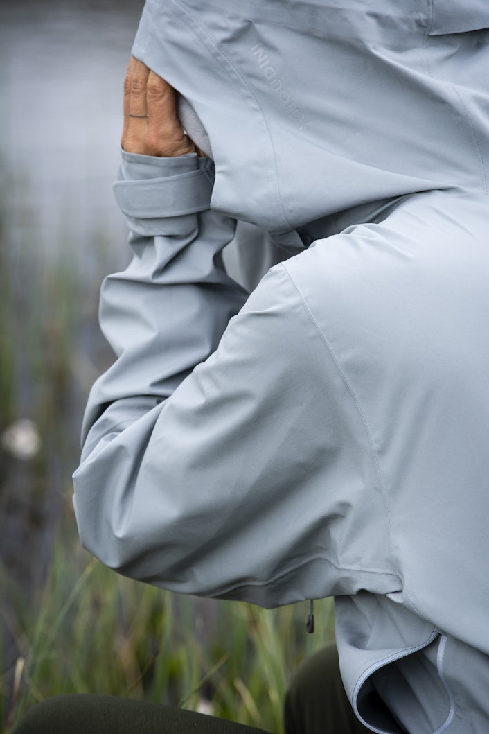 Close-up of a person in a grey raincoat.