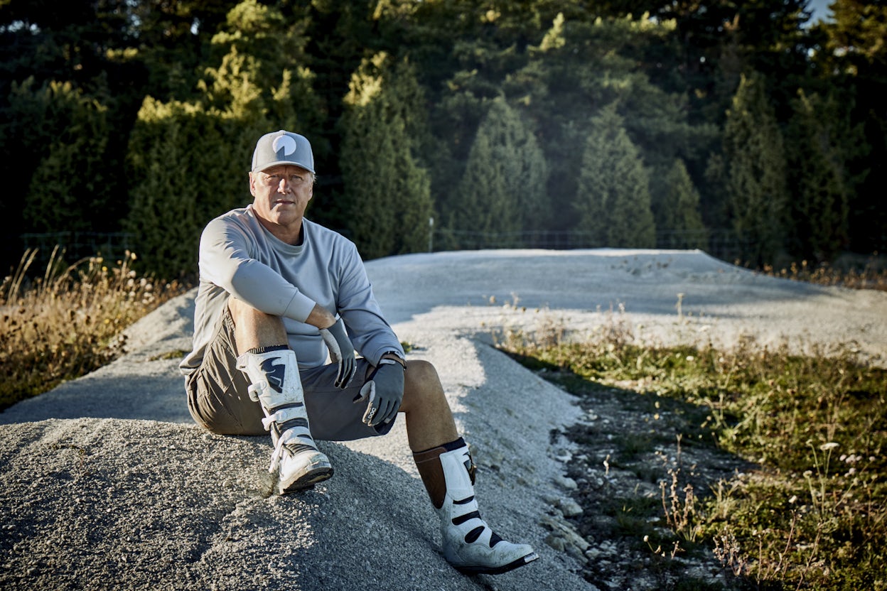 Stefan Ytterborn sitting on a rock in the forest on a sunny summer day.