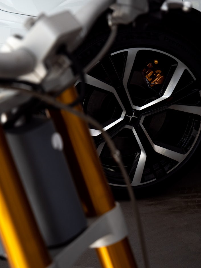 Close-up of a CAKE electric off-road motorbike with a Polestar wheel visible in the background.