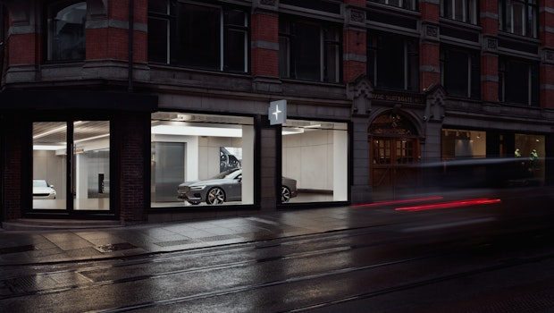 A street corner with a Polestar space where a Polestar 1 is visible through large glass windows.