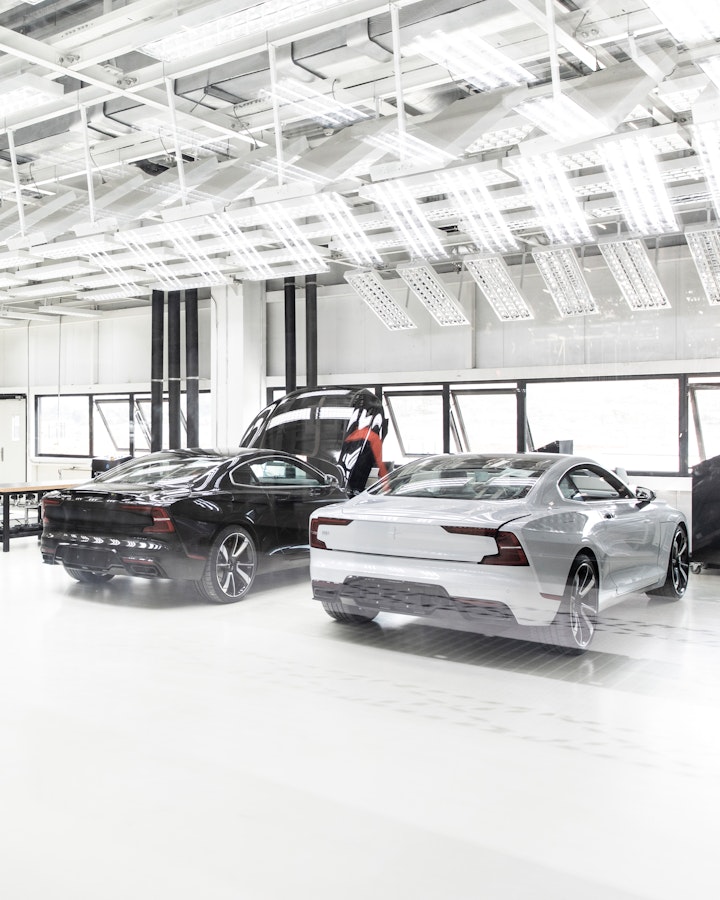 One Black and one white Polestar 2 parked inside a factory