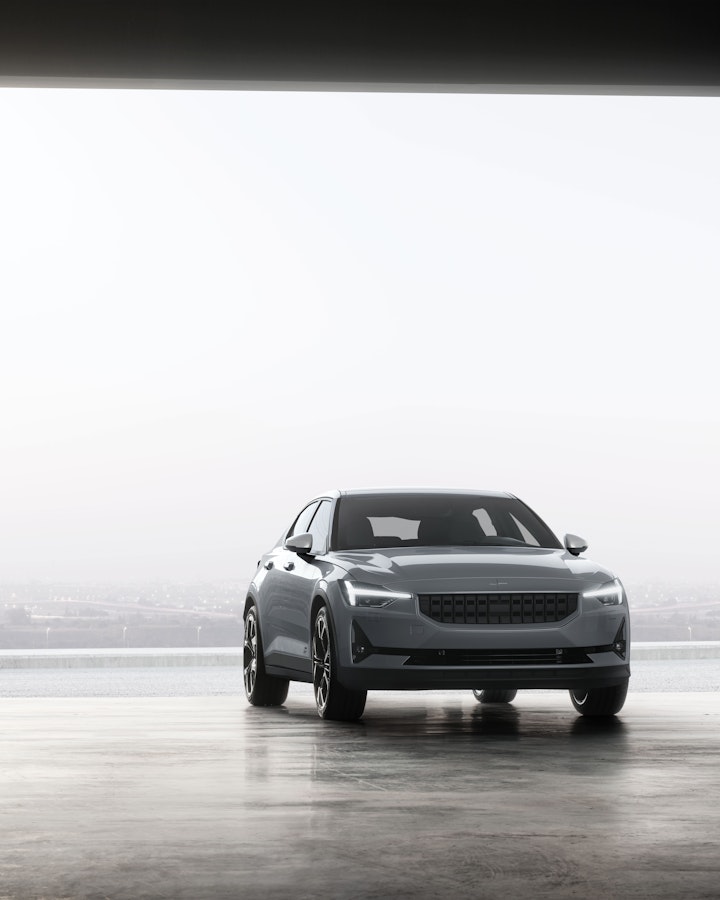 White Polestar 2 entering a big garage gate from outside 
