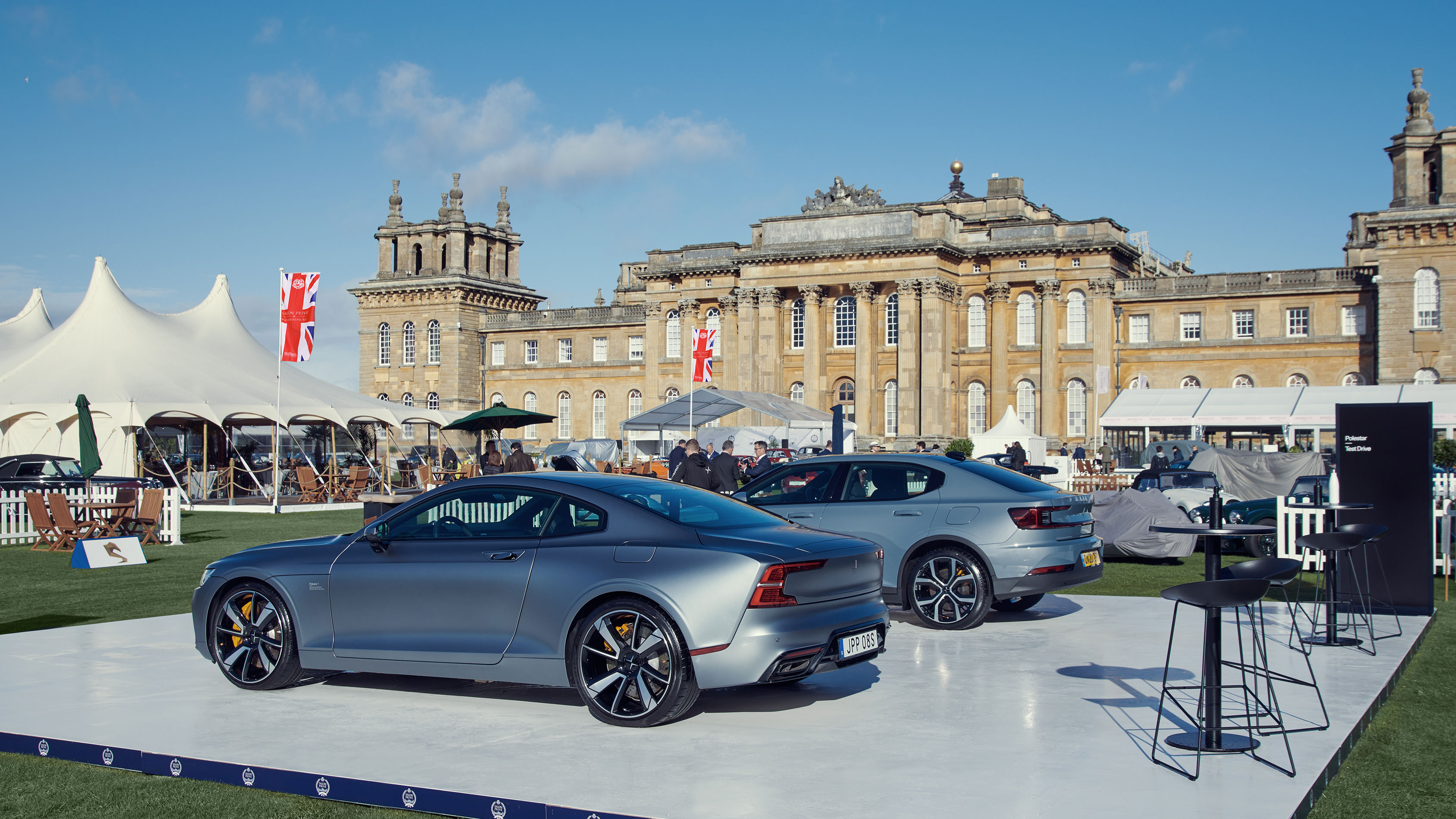 A Polestar 1 and a Polestar 2 on display in front of Blenheim Palace.