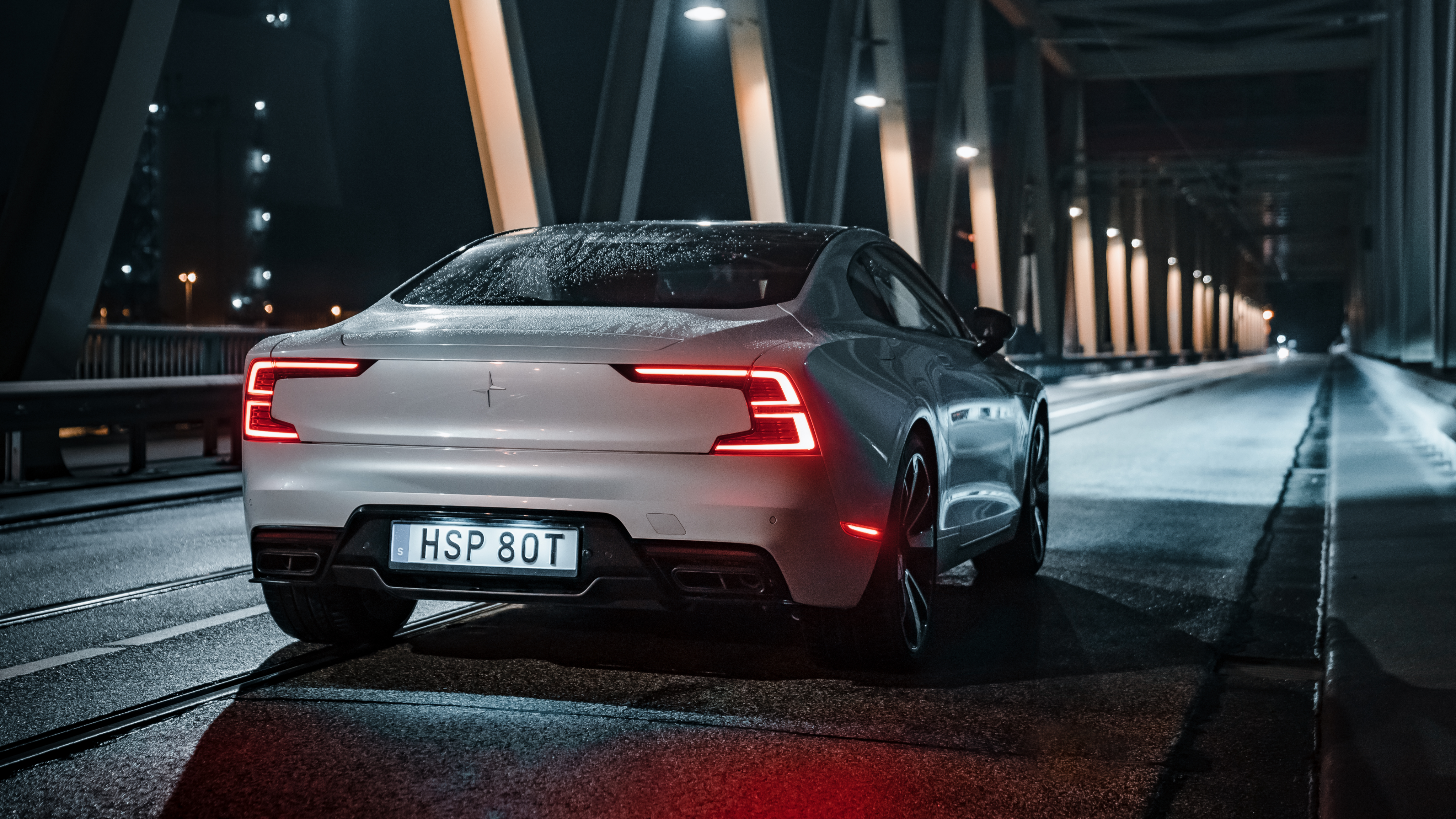 Back view of a Polestar 1 driving on a bridge at night.