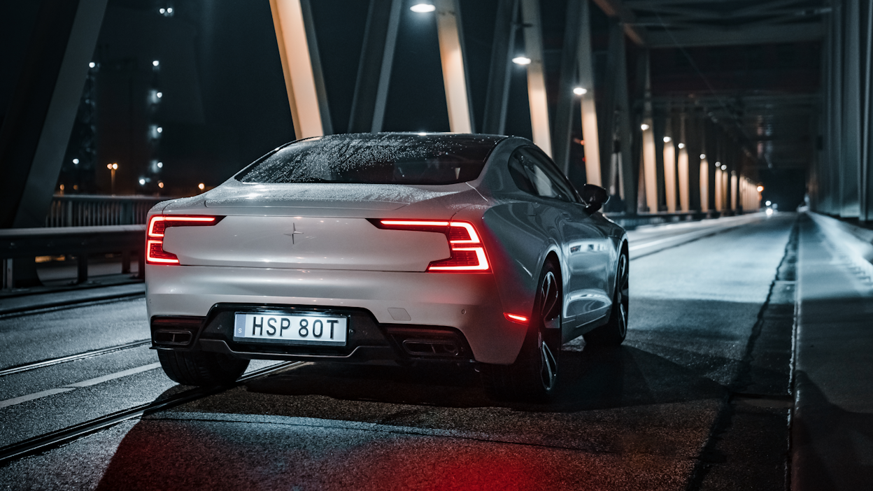 Back view of a Polestar 1 driving on a bridge at night.