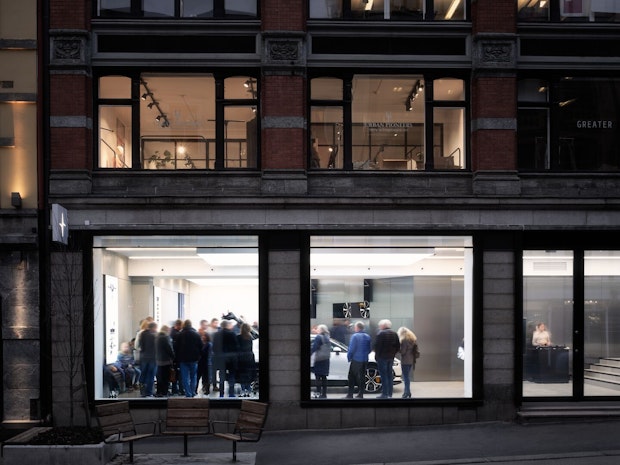 Outside view of a Polestar showroom with people inside discovering the car