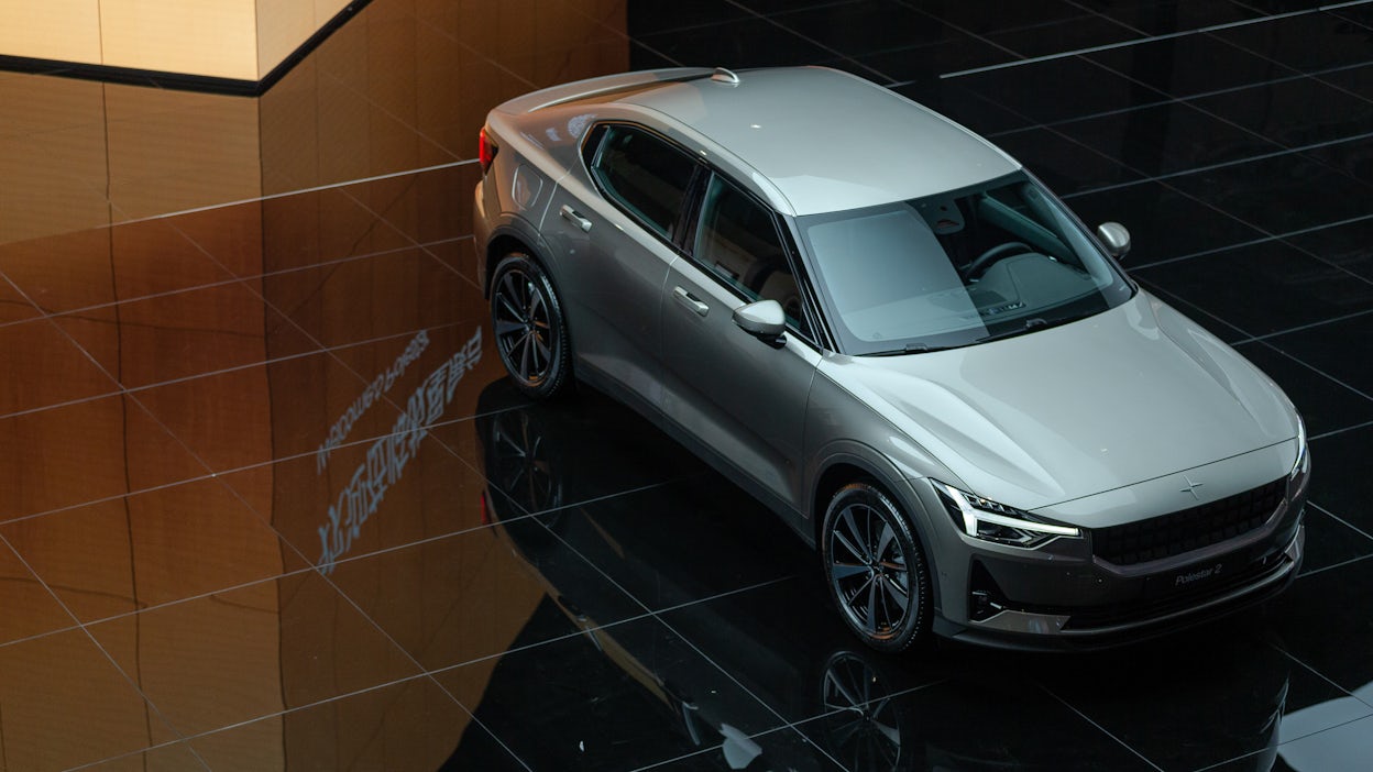 Grey Polestar 2 displayed on a shiny floor at Auto Shanghai 2021.