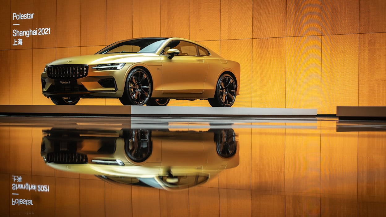 Golden Polestar 1 displayed on a orange-lit stage at the Auto Shanghai show 2021.