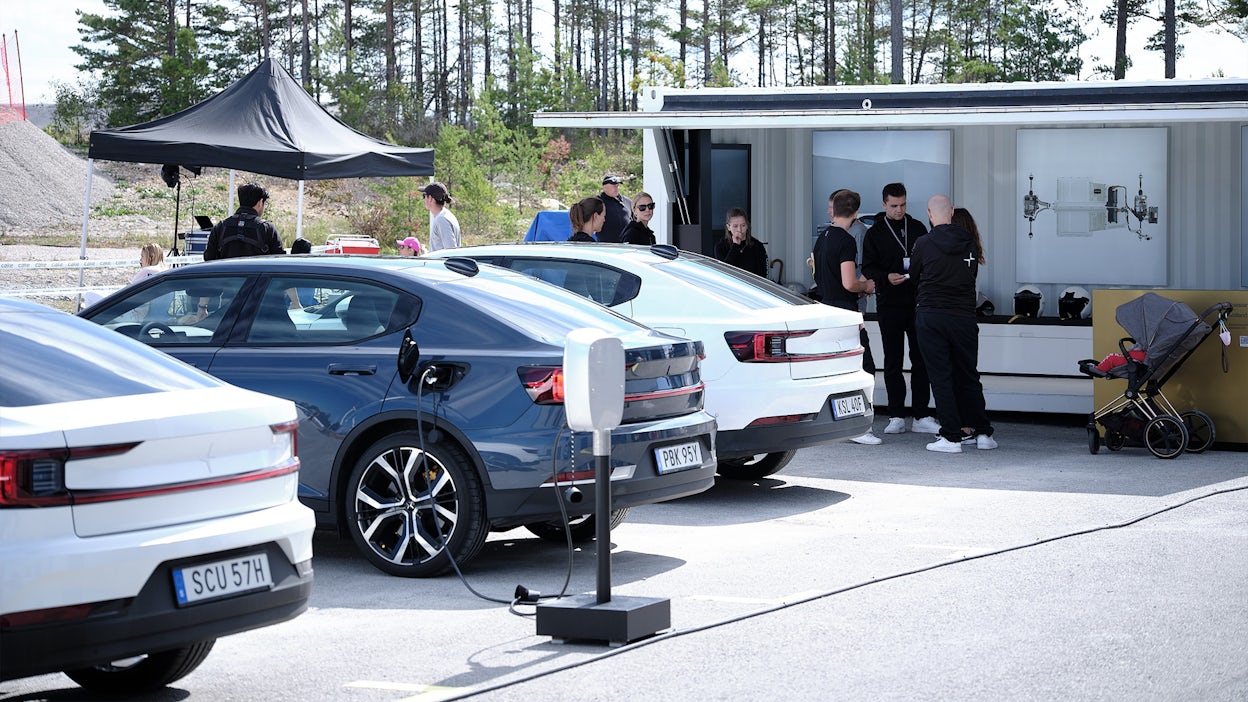 Polestar 2 cars parked next to each other with event staff gathered around them.