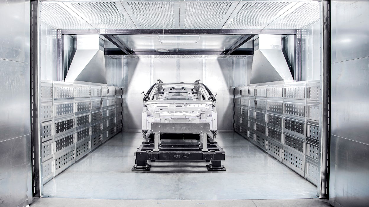 The bonded aluminium unibody of Polestar 5 displayed in a metallic room.