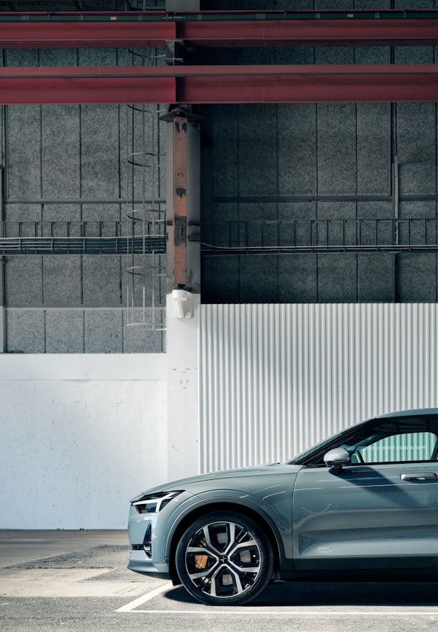 Side view of grey Polestar 2 parked in an industrial environment