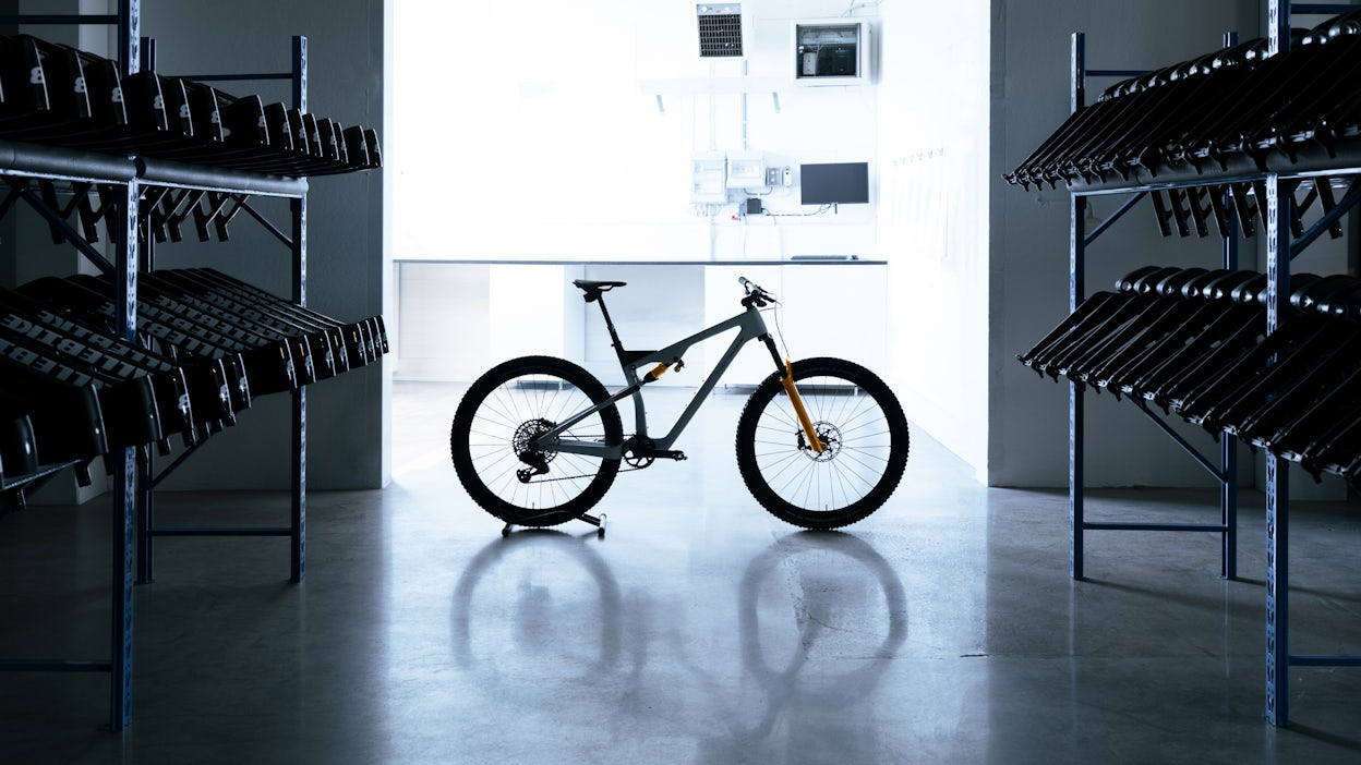 A backlit mountainbike in a warehouse. 