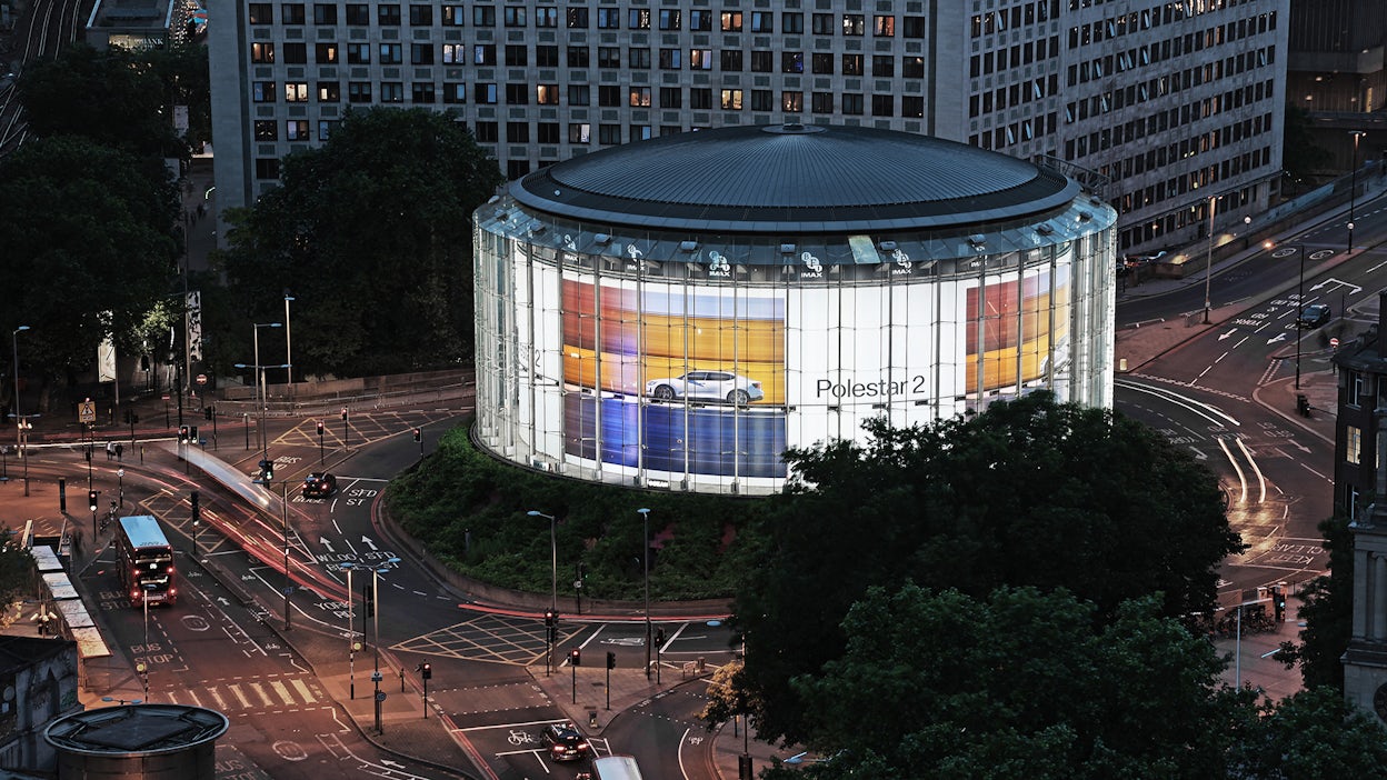 Digital billboard of Polestar 2 displayed on a round city building.