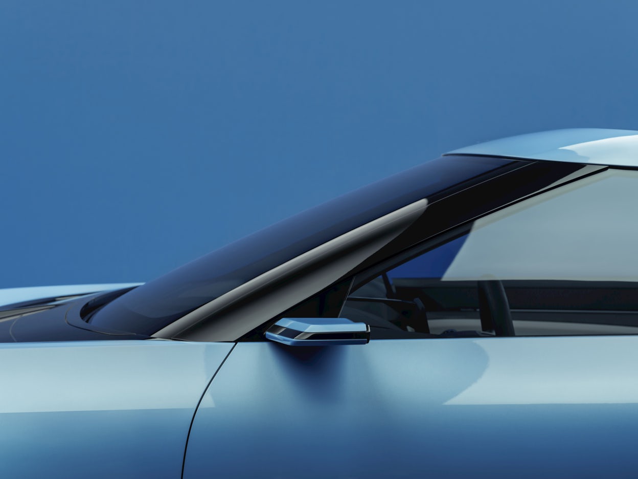 Camera side mirrors of a blue Polestar O₂ convertible.