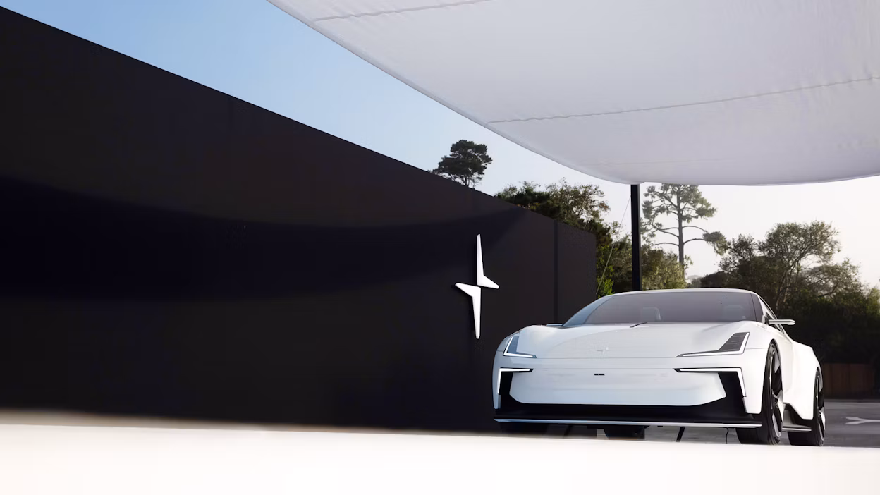 A white Polestar 6 displayed next to a black wall at Pebble Beach.