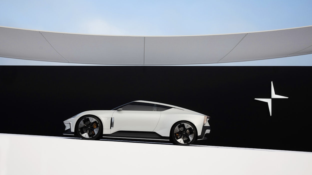 Side view of a white Polestar 6 in a exhibition space at Pebble Beach.