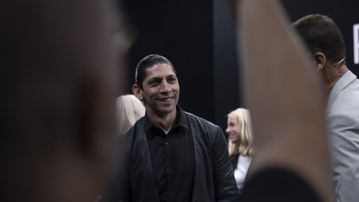 A man smiling in a crowd.