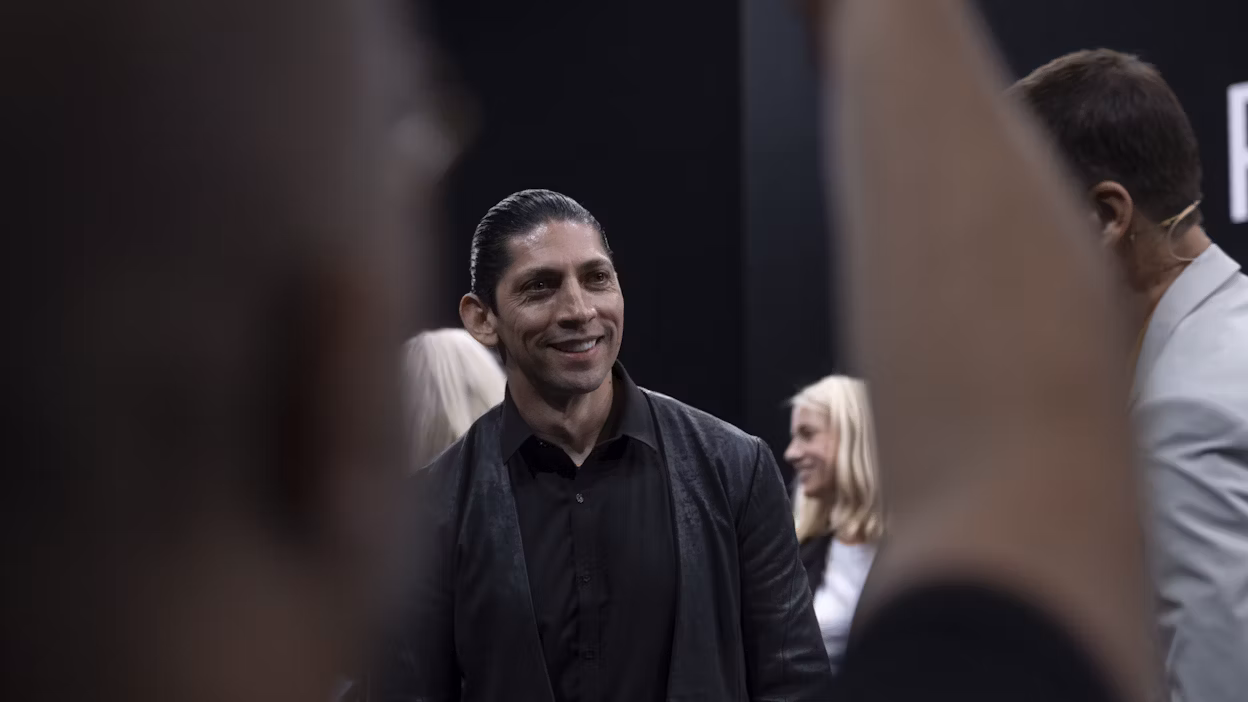 Designer Nahum Escobedo smiling while standing in a crowd of people.