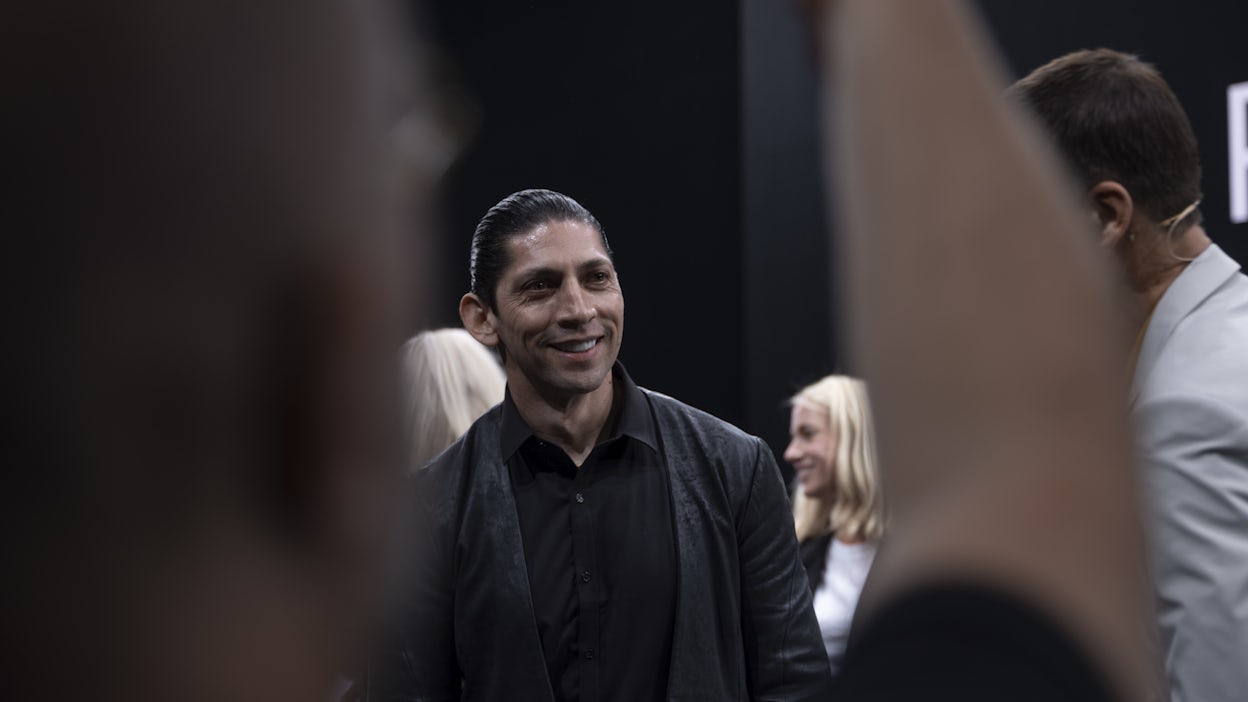 Designer Nahum Escobedo smiling while standing in a crowd of people.