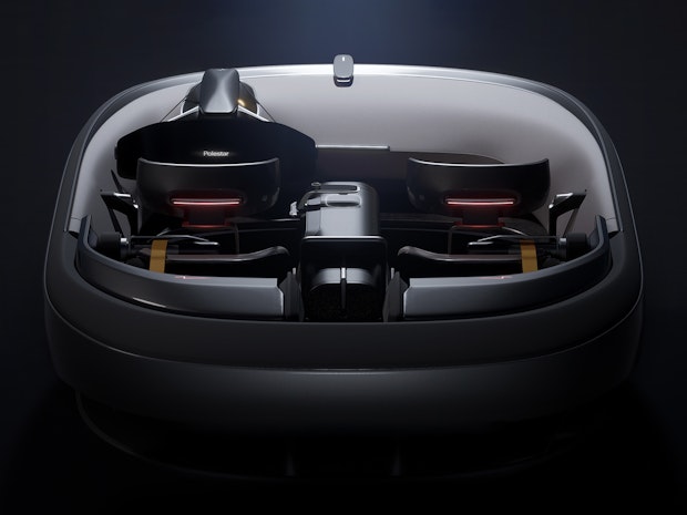 Interior of a Polestar car concept with two seats, steering wheel, and futuristic design elements in a dark setting.