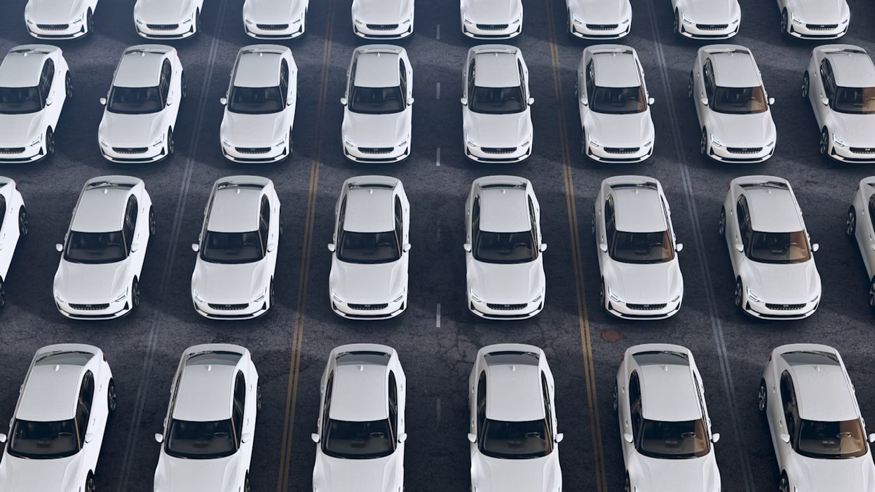 Several white Polestar 2 cars parked in rows at a parking lot.