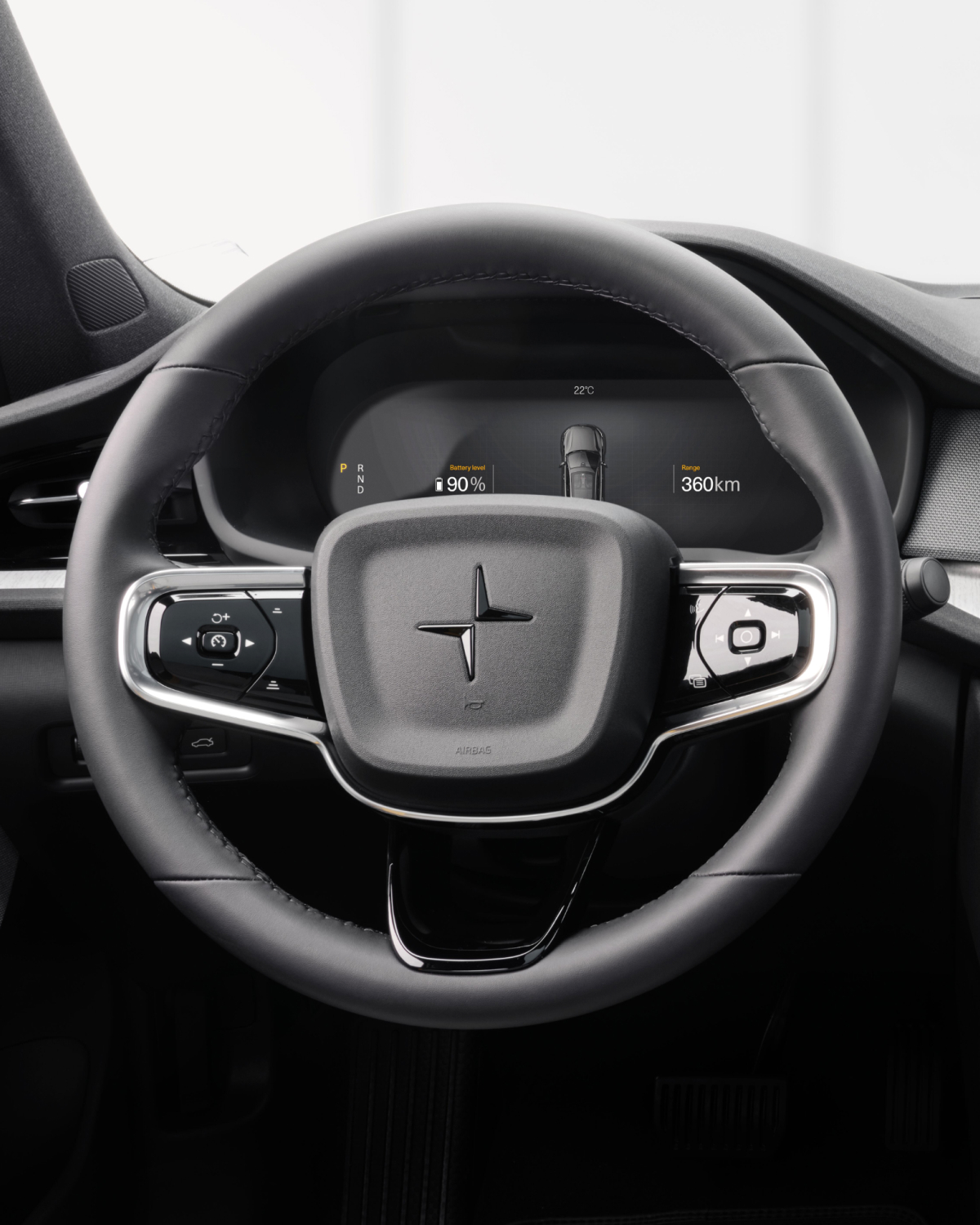 Inside the Polestar 2 showing a black steering wheel with the Polestar logo in the middle
