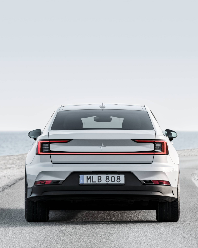 Showing the back of the Polestar 2 on a road.