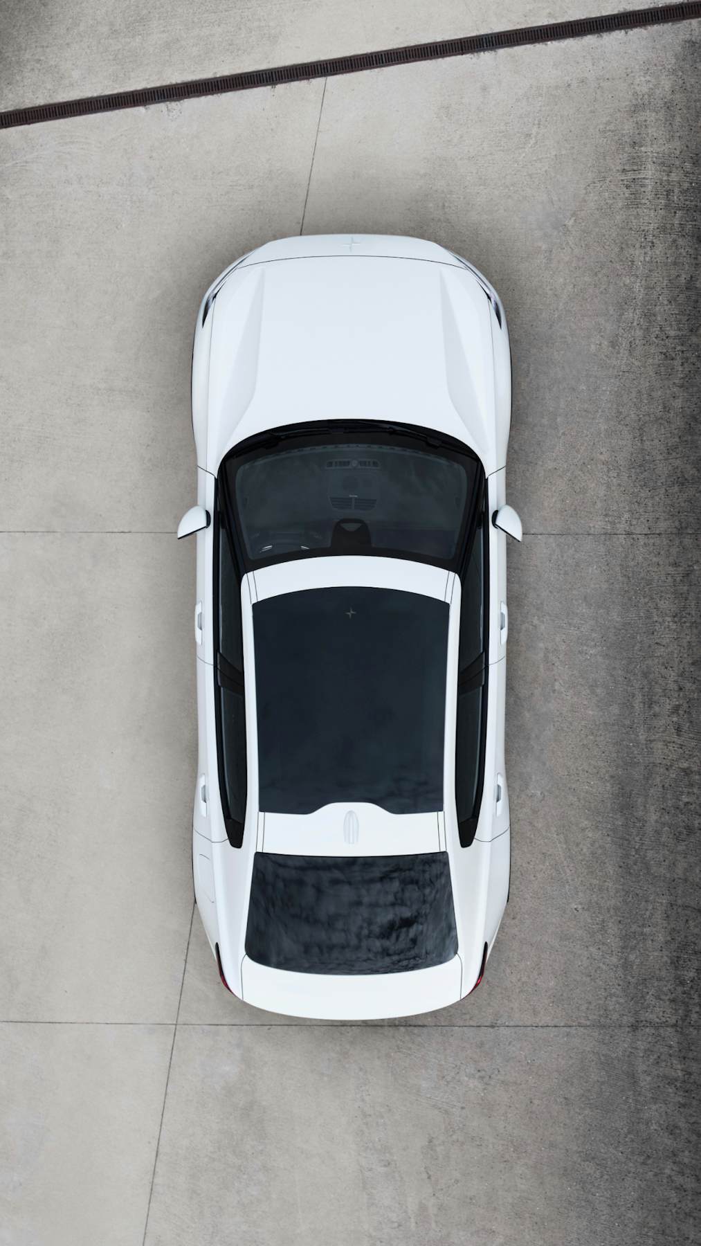 Top view of a white Polestar 2 parked on a concrete floor