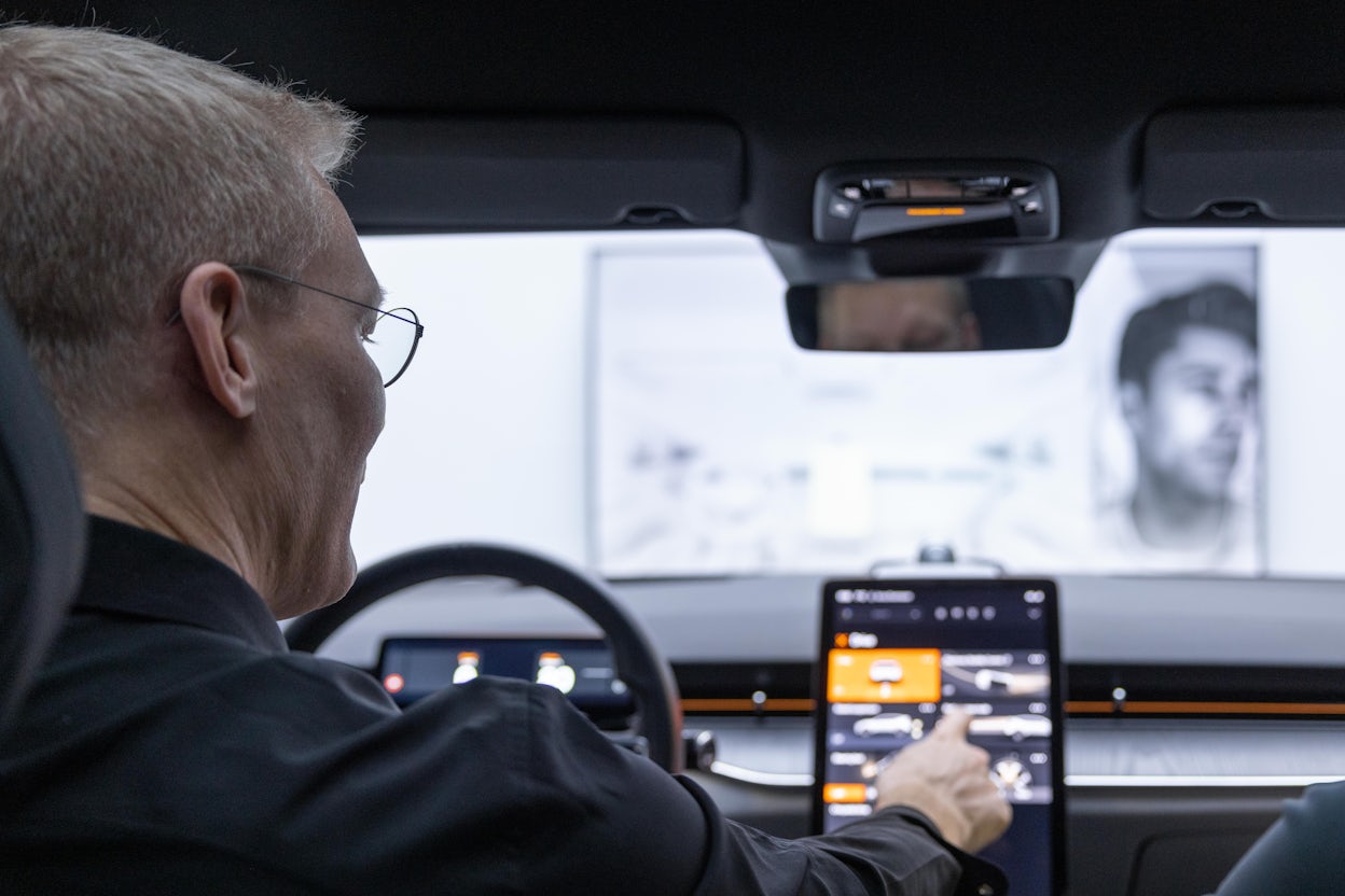 Polestar COO Dennis Nobelius in a Polestar, touching the in-car display.