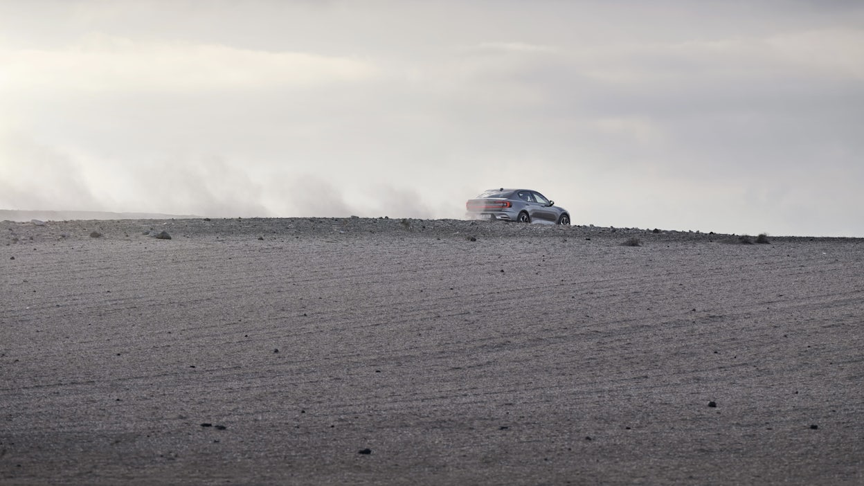 Polestar 2 driving in a desert looking environment