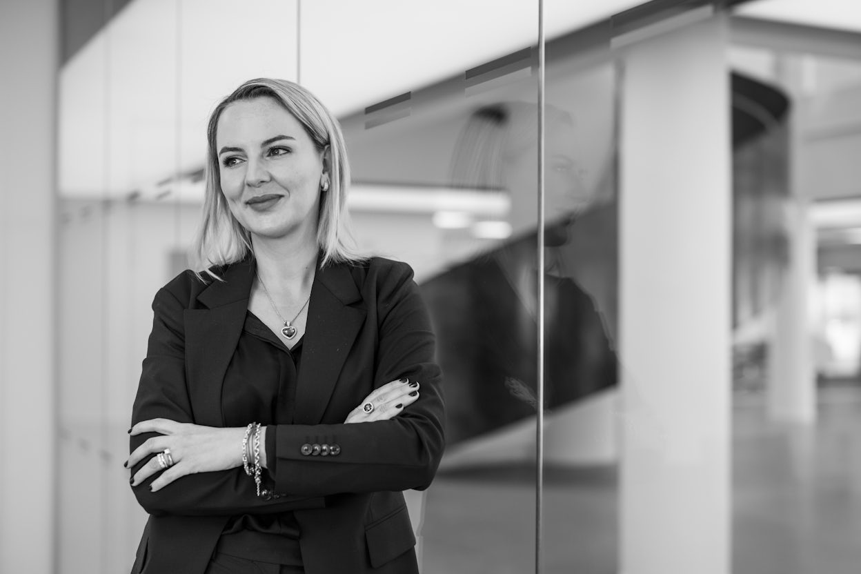 Arlena Amiri standing in front of a glass building.