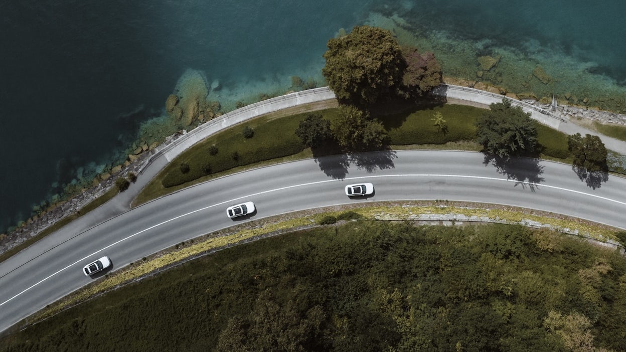 Arial view of Polestar 2 driving beside lake