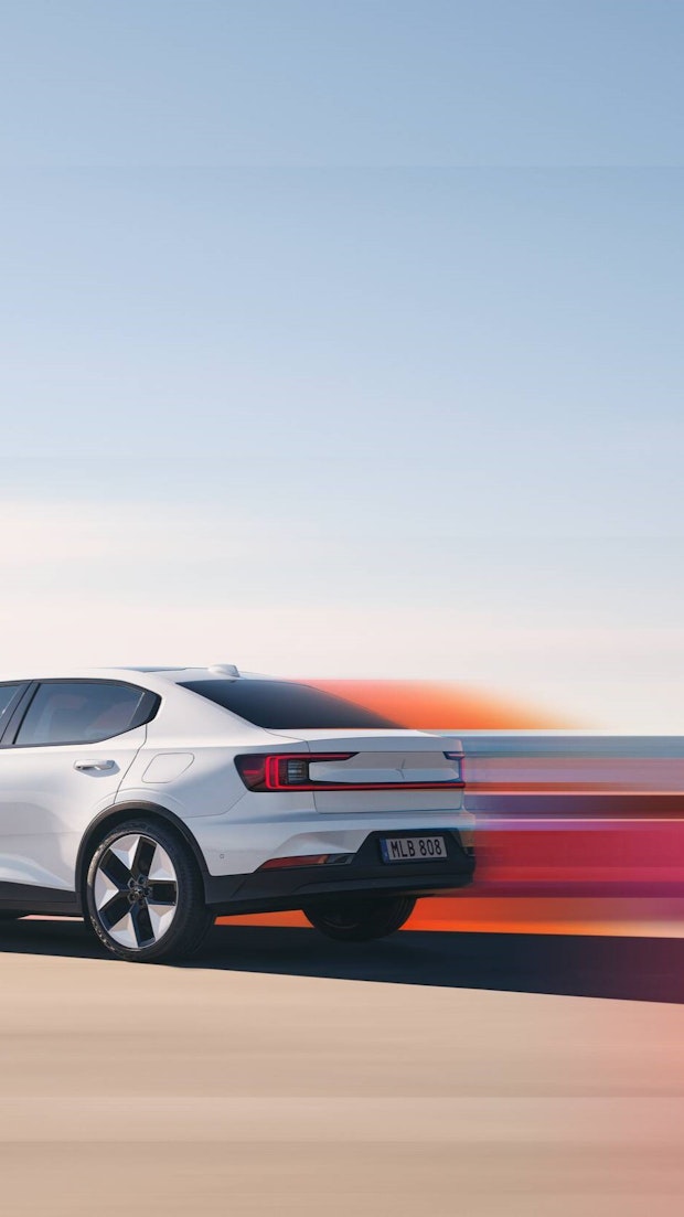 Polestar 2 in the exterior colour snow driving in motion blur with red coours, with a side view