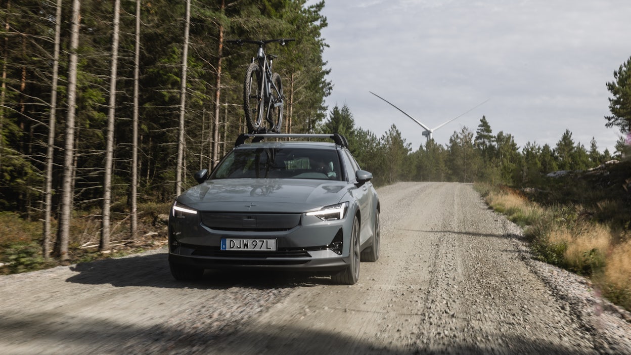 Polestar 2 with Allebike bike on roof driving down forest road